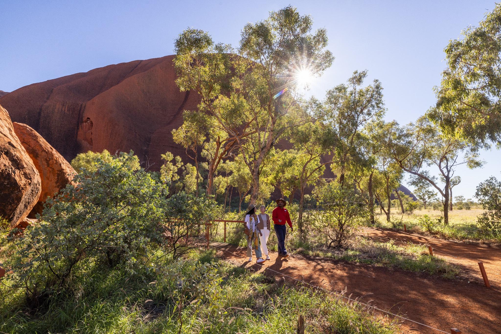 Women Following A Guide Walking On A Path Among The Mountains