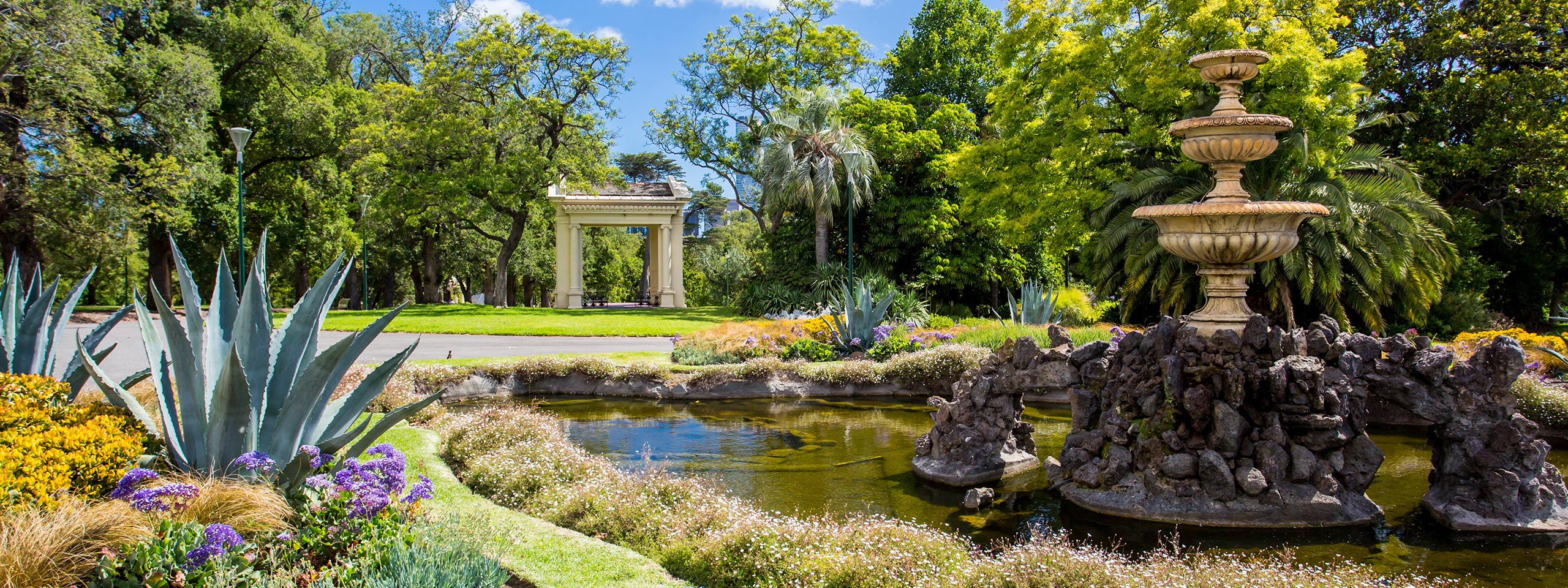 Beautiful garden with pond and fountain on a sunny day