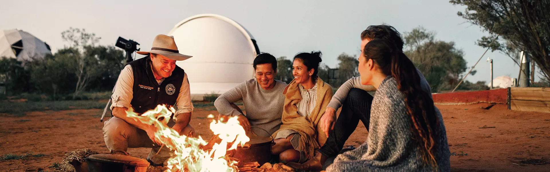A group of people sitting around a campfire