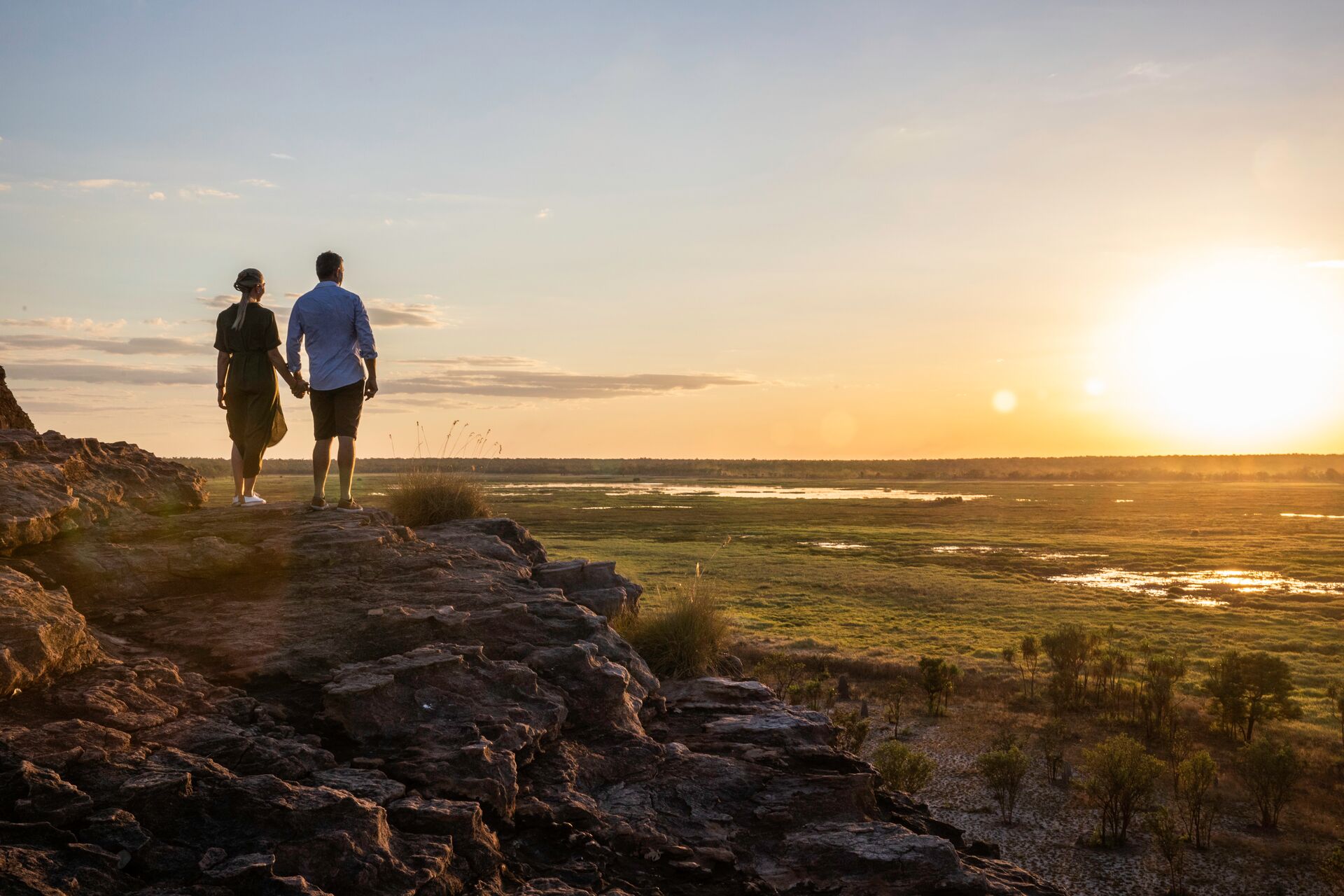 A couple of people standing on top of a rocky hill