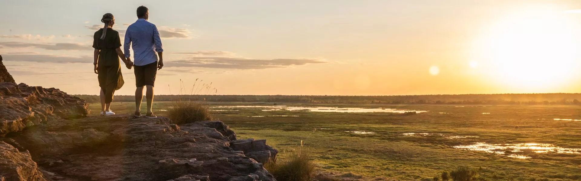 A couple of people standing on top of a rocky hill