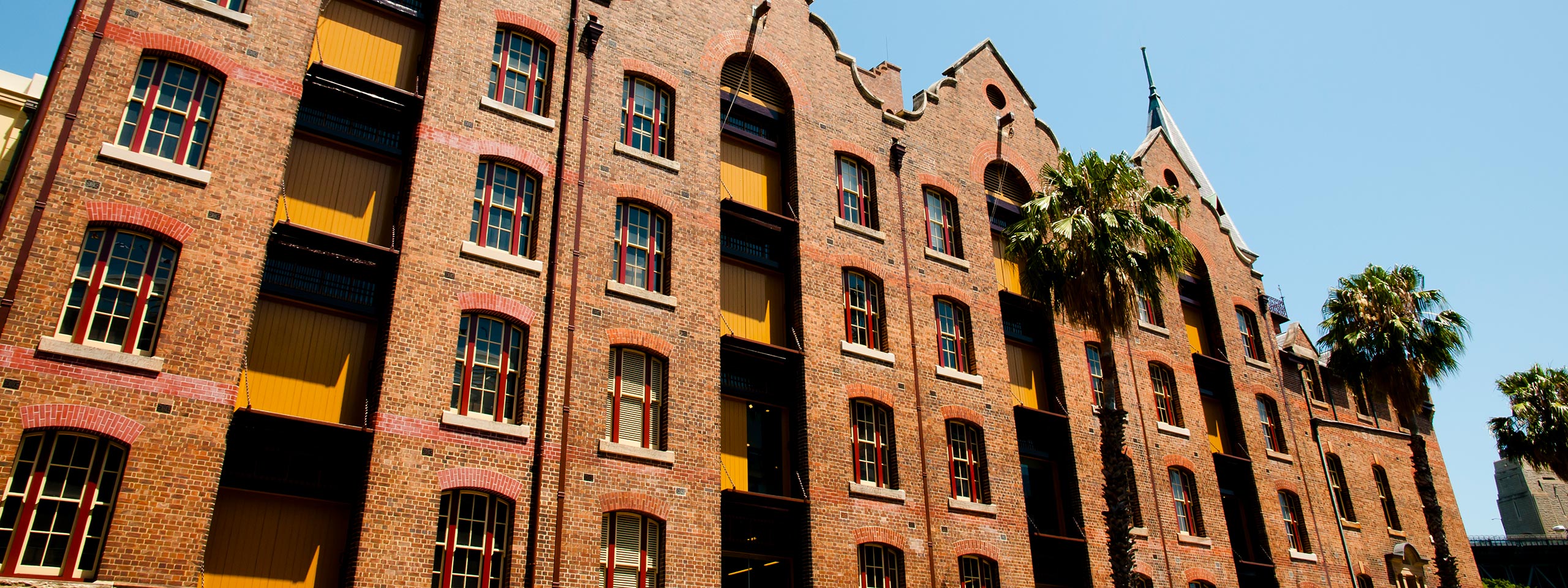 A tall brick building with palm trees in front of it