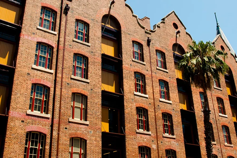A tall brick building with palm trees in front of it