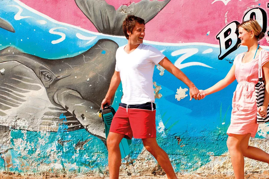 A couple with Bondi Beach street art in the background