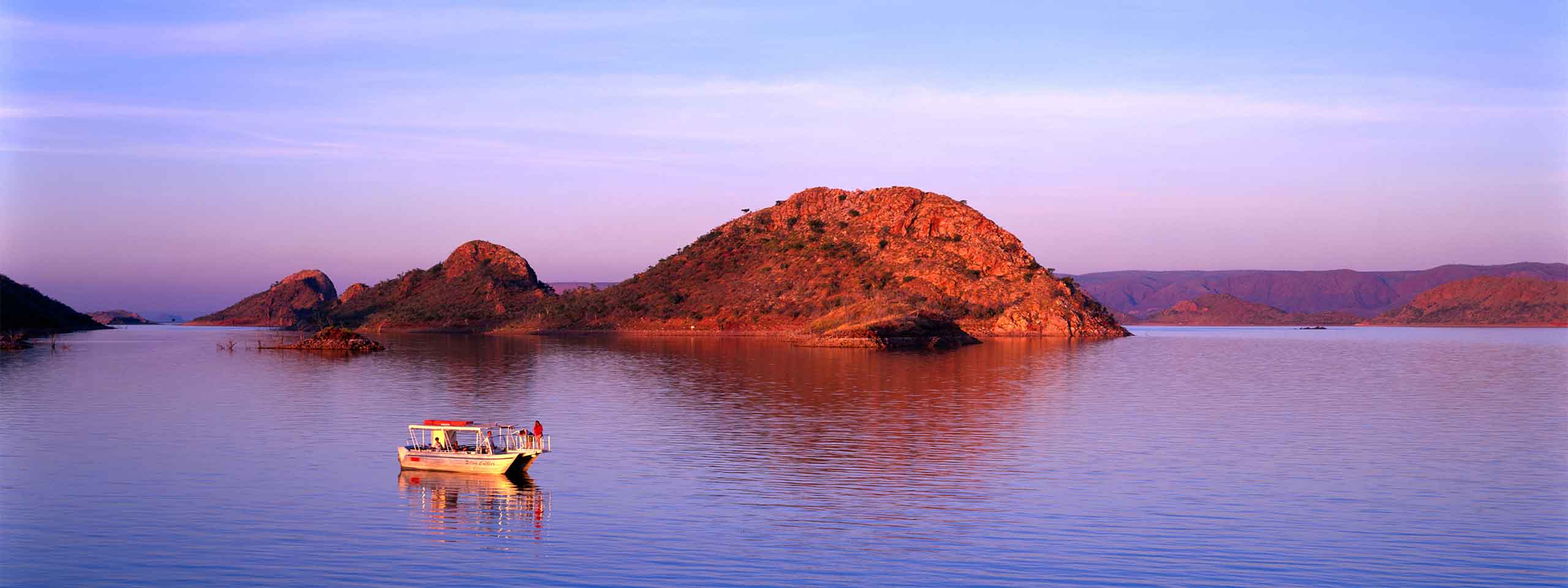 A boat on Lake Argyle by sunset