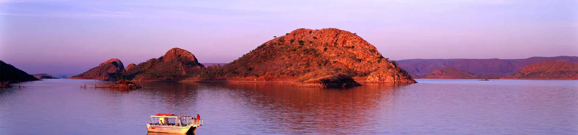 A boat on Lake Argyle by sunset