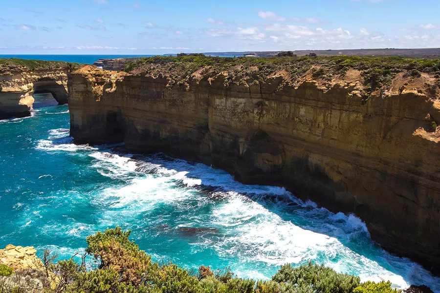 Rock formation by the water with greenery