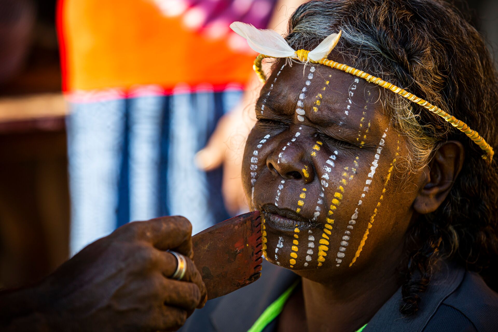A woman with a painted face and a feather on her head