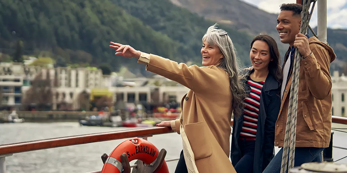 People on a boat floating among mountains and city