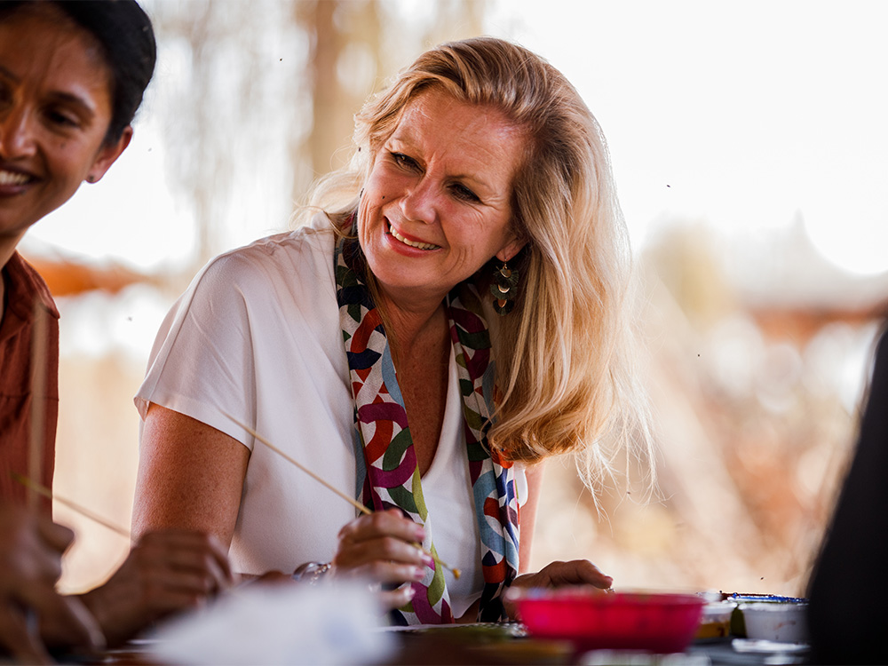 An older woman sitting at a table next to a man