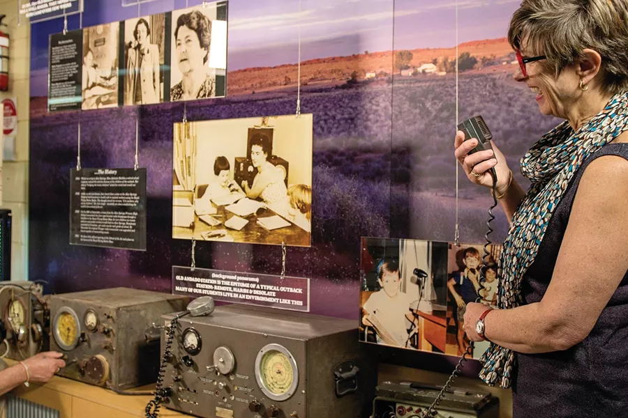 A woman standing next to a man in front of a wall with old devices