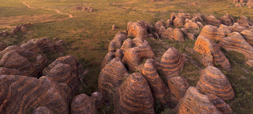 Aerial view of the beehive-shaped sandstone domes of the Bungle Bungles at sunset. 