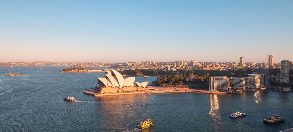 Aerial image of Sydney Harbour with the Opera House and boats in the water.