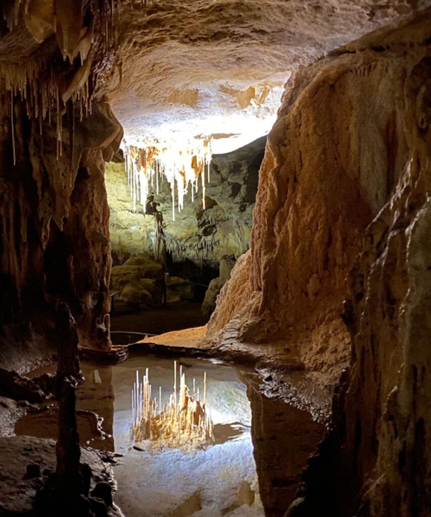 A limestone cave lit by a warm natural glow.