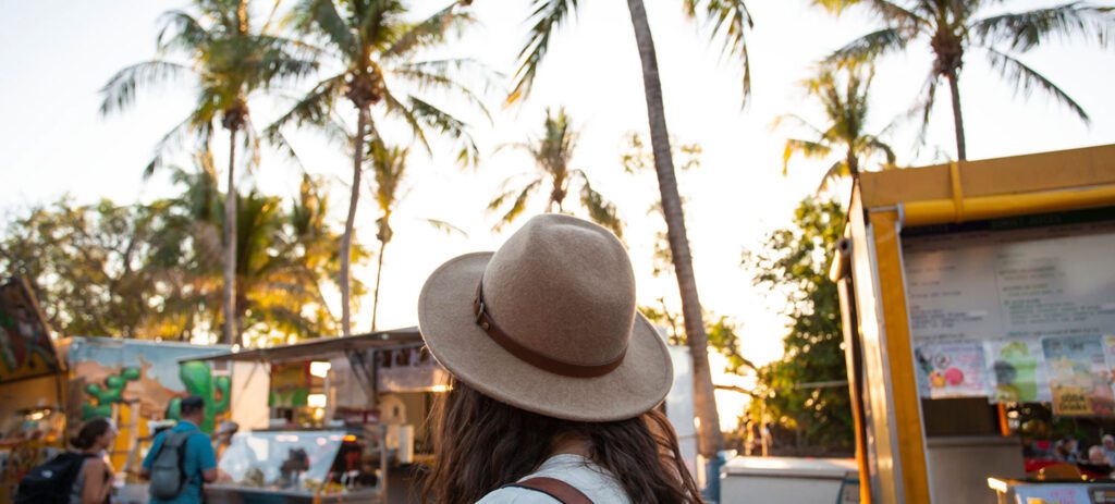 Person viewing the Mindil Beach Sunset Market stalls at sunset.