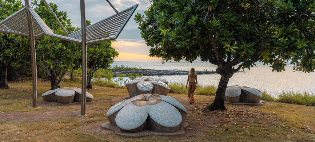 Woman gazing across the water at East Point Reserve, a coastal park known for its military history in Darwin, NT.
