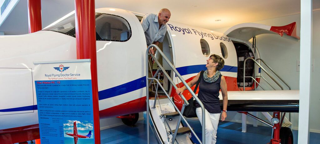 Two visitors exploring the aircraft on display at the Royal Flying Doctor Service Alice Springs Tourist Facility, Northern Territory.