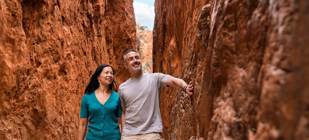Two visitors walking through the towering walls of Standley Chasm, Northern Territory.