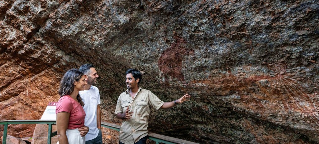 Guide sharing Aboriginal rock art stories with travellers at Kakadu National Park