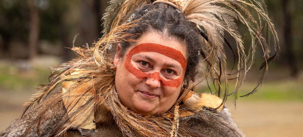 Trish from NITA Education wearing traditional clothing surrounded by trees