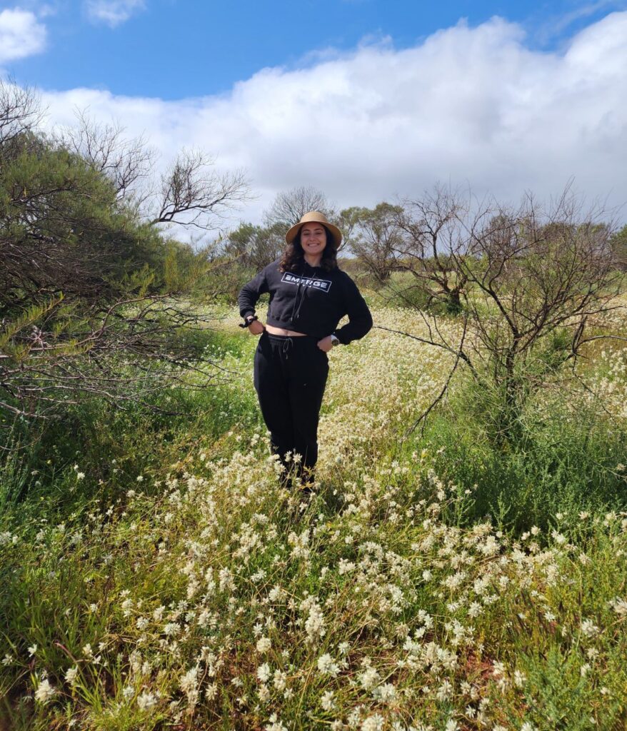 A girl in black standing in a field of Western Australian wildflowers