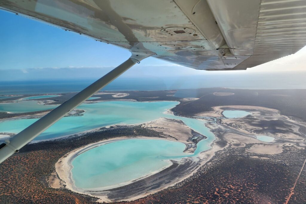 View over a bay with turquiose water from a light aircraft scenic flight