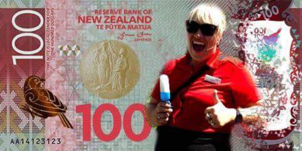 Isobel playfully posing with a New Zealand hundred dollar note while enjoying an ice cream, showcasing local currency and treats.